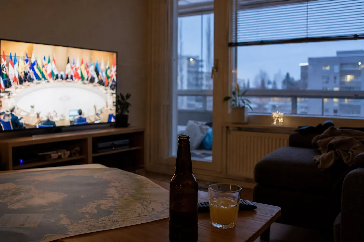 Hervantalaisen olohuoneen televisiossa näkyy epätarkka kansainvälinen kokous, ja pöydällä on arktisen alueen kartta sekä juomalasit.