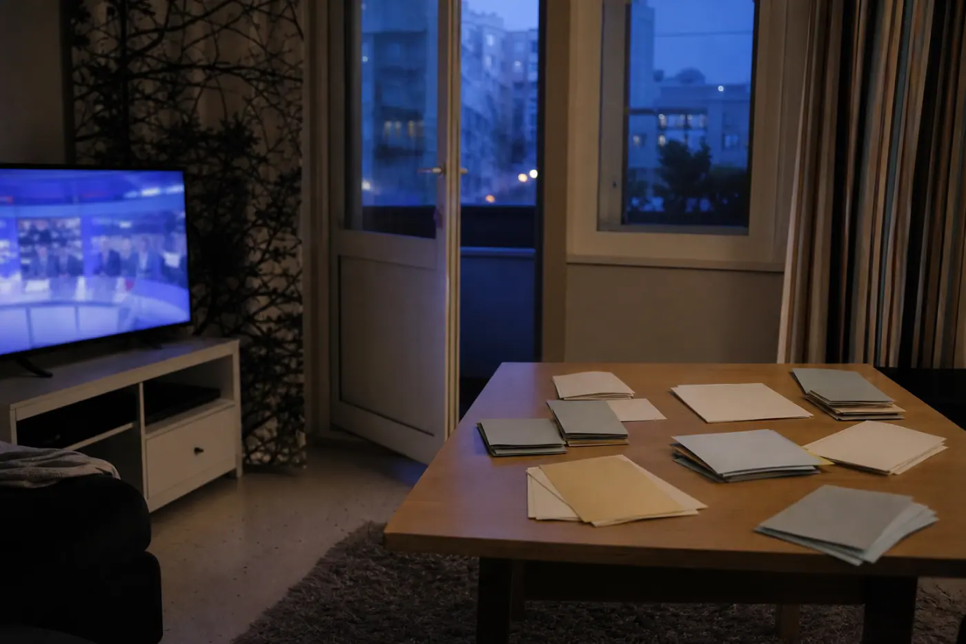 Hervantalaisen asunnon olohuoneessa on pöytä, vaalipapereita ilman luettavaa tekstiä ja televisio, jonka uutislähetyksestä näkyy vain epätarkka värikuva.