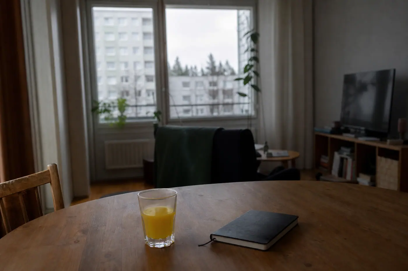 Hervantalaisen asunnon olohuoneen pöydällä on muistivihko ja lasi mehua, ikkunasta näkyy kerrostaloja.