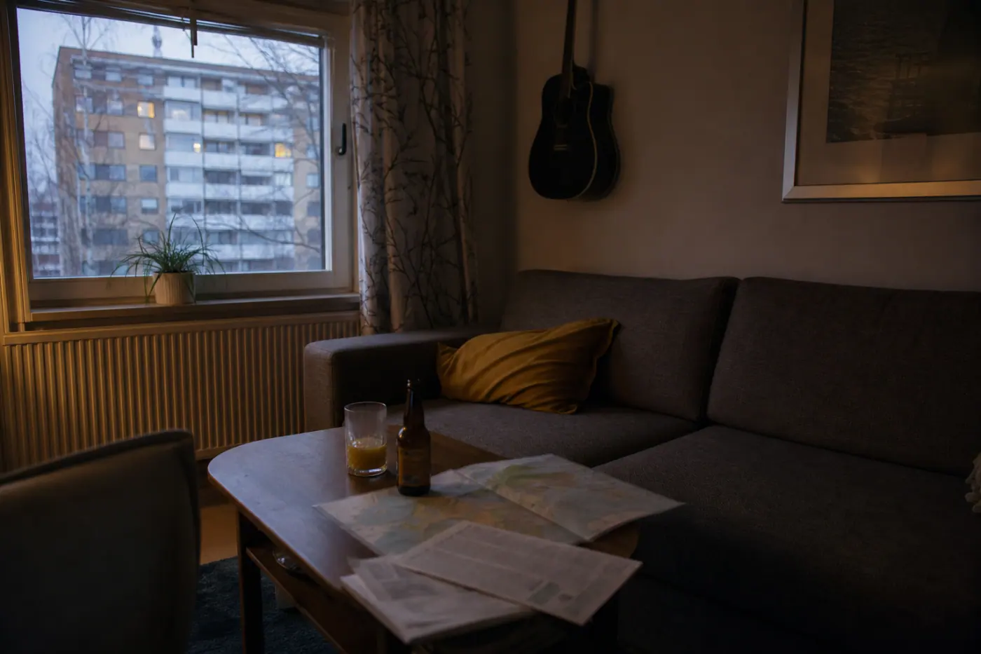 Hervantalaisen asunnon olohuoneessa on sohva, pöydällä mehulasi, kaljapullo ja maailmankartta.